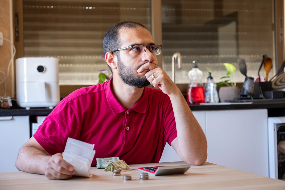 Man sitting kitchen Calculating costs Living
